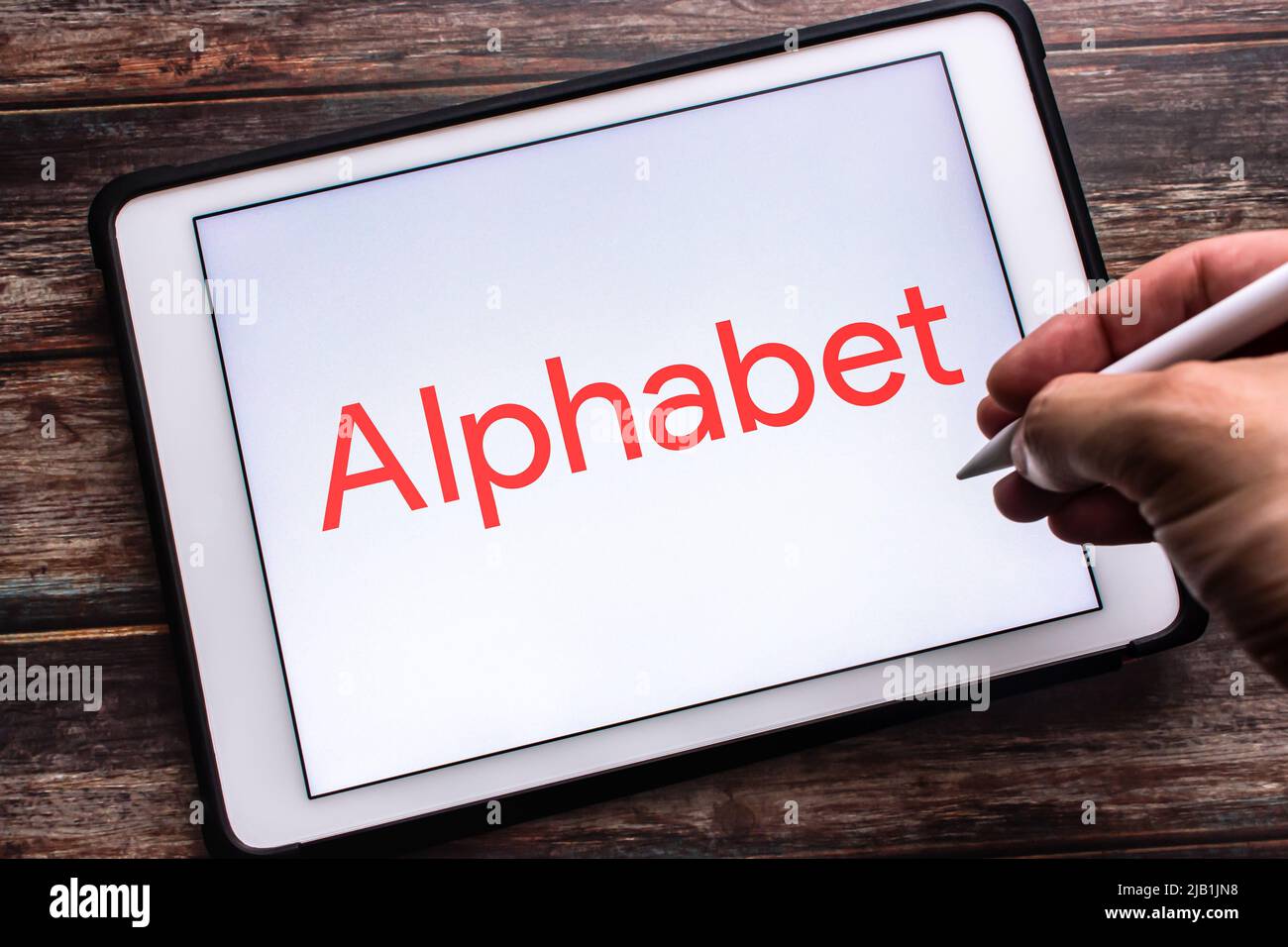 Kumamoto, GIAPPONE - Lug 30 2021 : Logo del conglomerato multinazionale Alphabet inc. (Una ristrutturazione di Google il 2 2015 ottobre) su tablet. Uomo che tiene la penna Foto Stock