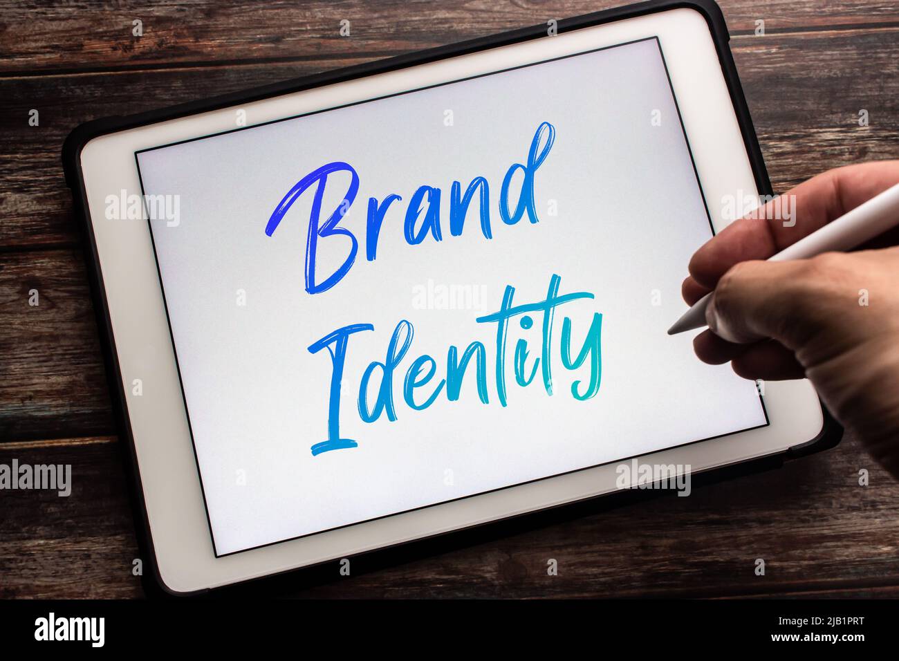 Closeup parola chiave Brand Identity su tablet. Definire l'immagine giusta per il consumatore o i clienti. Costruire il concetto di marchio con creatività. Uomo mano che tiene la penna Foto Stock