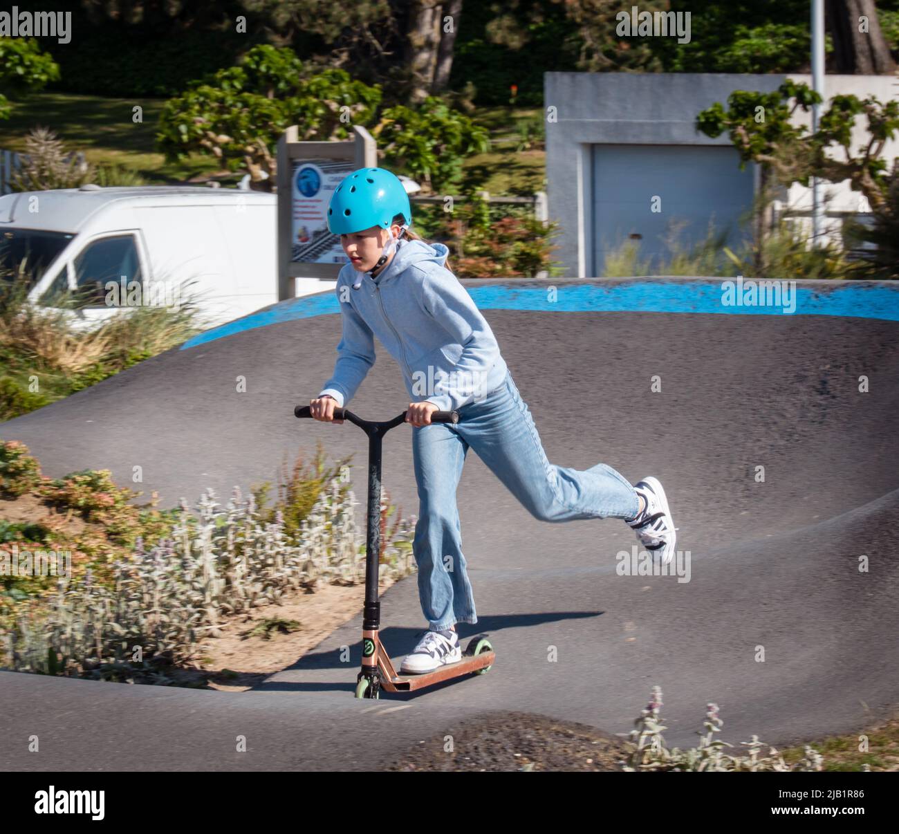 Merville, Francia maggio 2022. Bambini che indossano caschi scooter su una pista sportiva in una giornata di sole, vacanze estive Foto Stock