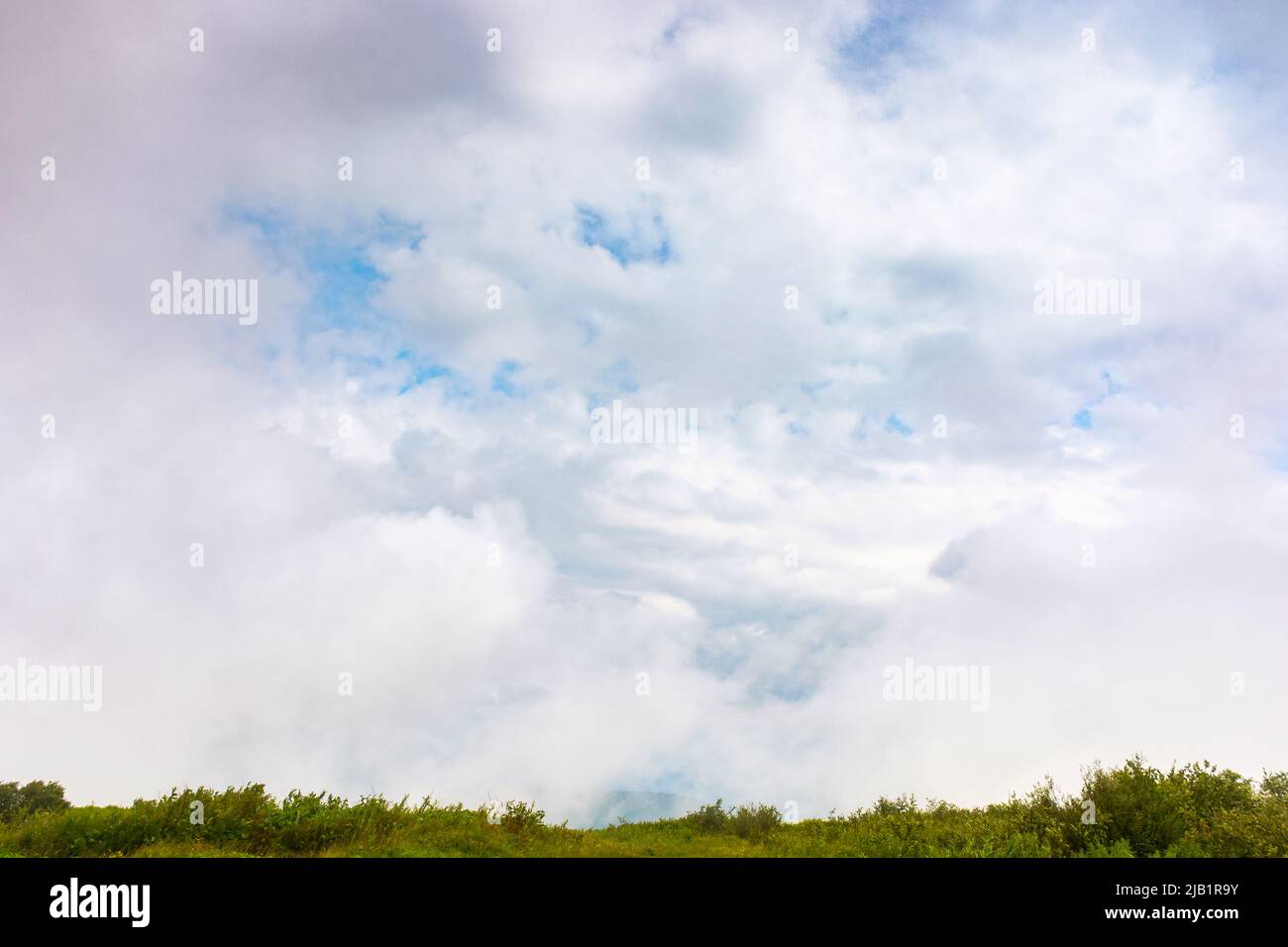 cielo nuvoloso sopra il prato verde. paesaggio naturale con linea d'orizzonte. bellissimo paesaggio al mattino Foto Stock