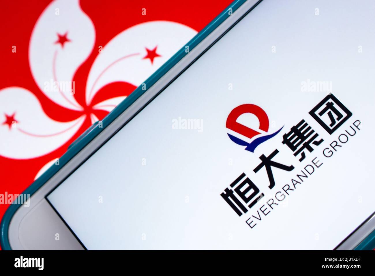 Logo dell'Evergrande Group (Evergrande Real Estate Group, precedentemente Hengda Group), sviluppatore di proprietà leader in Cina, su iPhone con bandiera di Hong Kong. Foto Stock