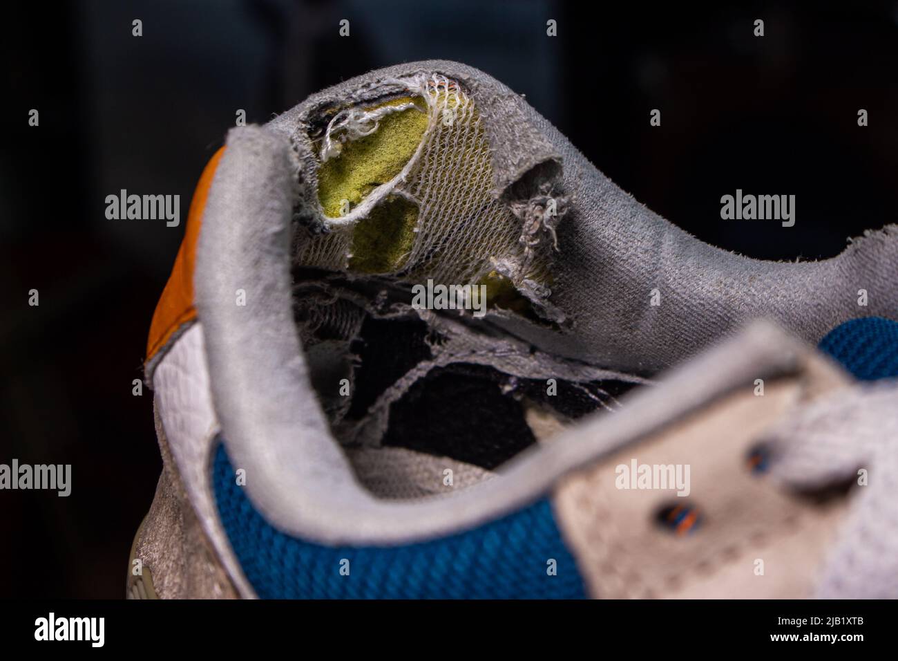Primo piano vecchie scarpe rotte. La parte del tallone della scarpa nell'immagine è usurata e danneggiata. Foto Stock