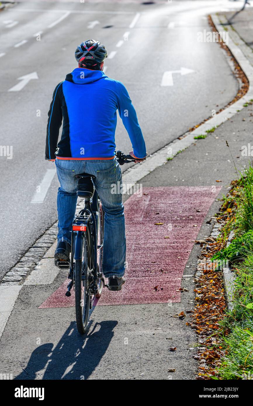 Il ciclista passa dal percorso ciclabile a quello ciclabile e a quello pedaliera Foto Stock