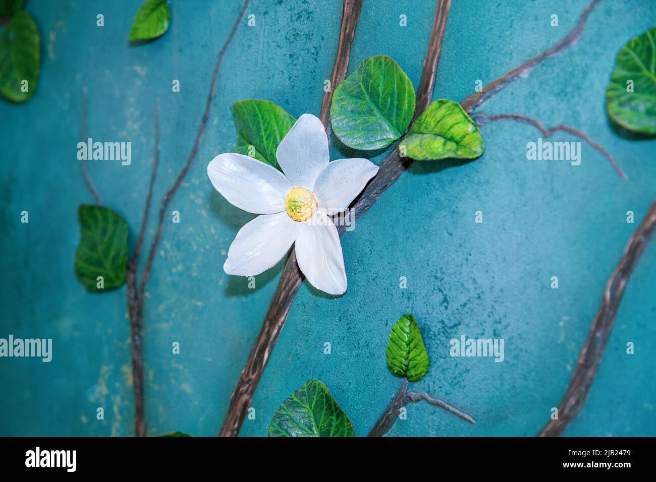 Dettagli interni fatti a mano - fiori in argilla modellante autindurente su una parete ruvida. Foto Stock