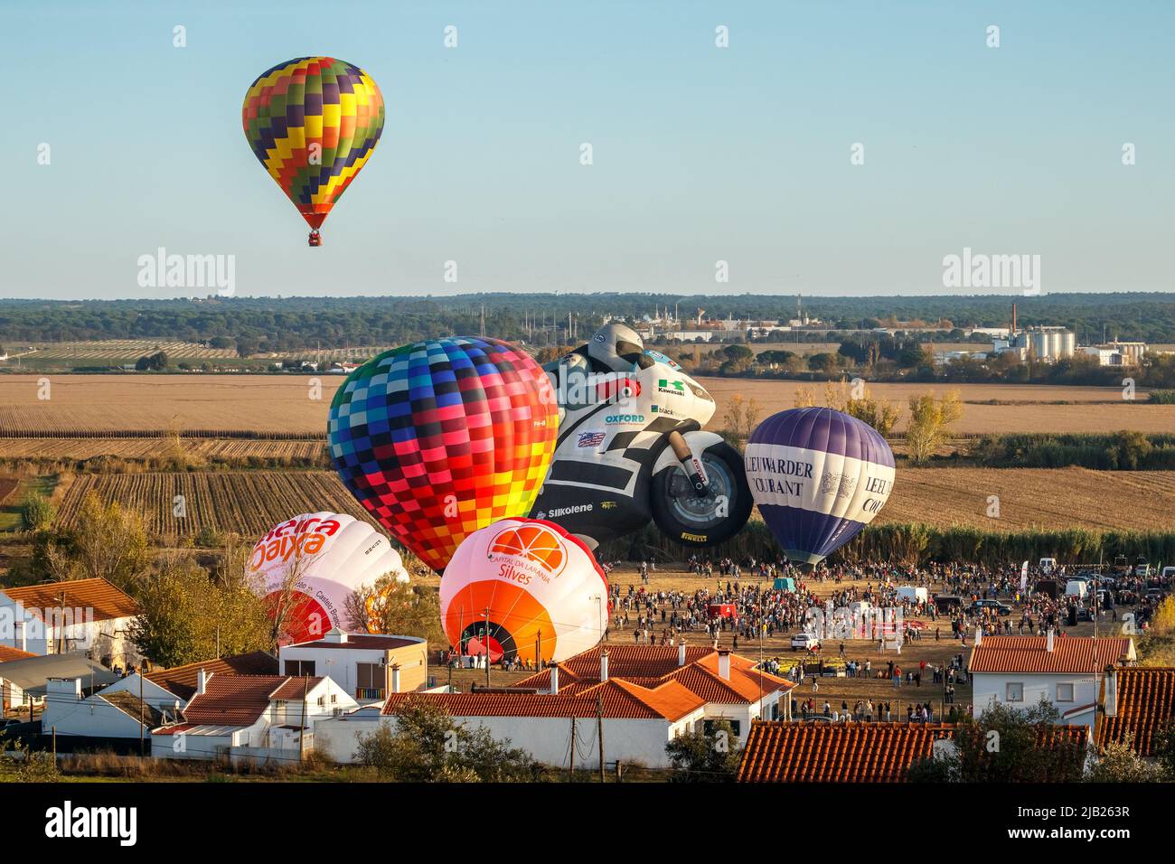 Coruche, Portogallo - 13 novembre 2021: Vista di mongolfiere pronti a decollo e un altro mongolfiera già in aria. Foto Stock