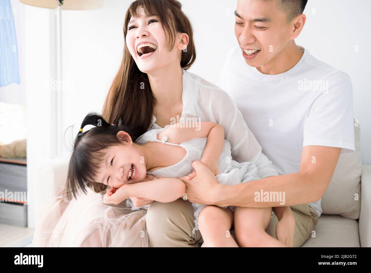 Felice famiglia asiatica divertirsi a casa. Foto Stock