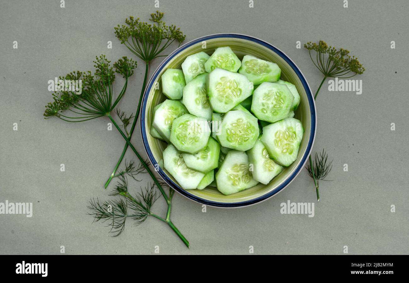 Succulenta insalata di cetrioli crudi in un piatto su un tavolo di legno con aneto Foto Stock