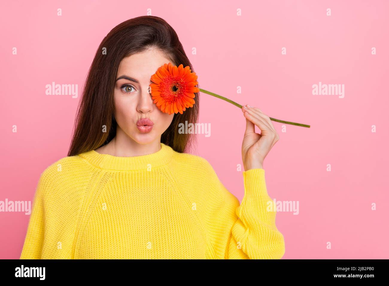 Foto di giovane bella ragazza copertina occhio fiore pointed labbra cosmetologia procedura isolato su sfondo rosa colore Foto Stock