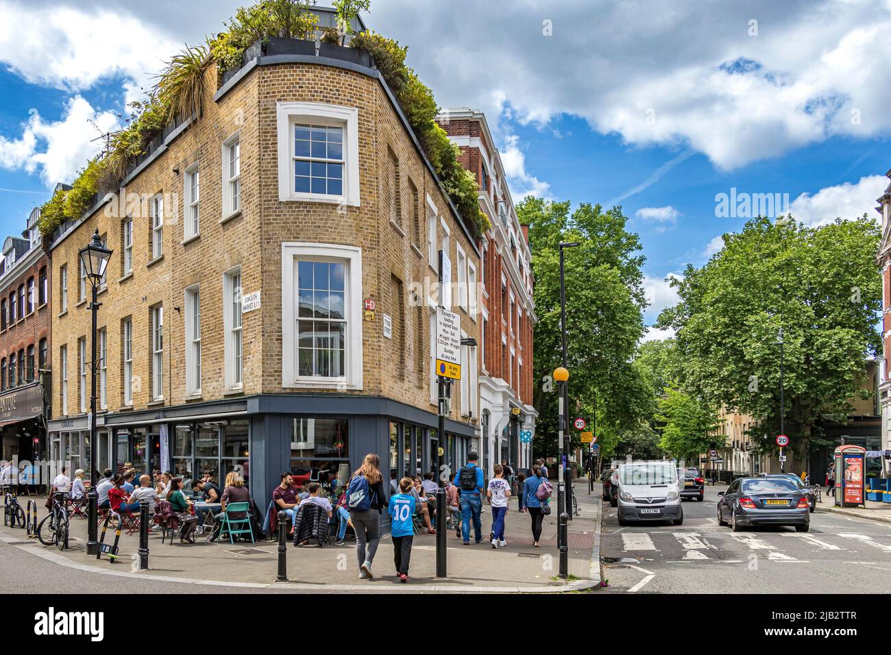 Persone seduti fuori Briki, un'affollata deli, caffetteria e birreria di caffè all'Exmouth Market, Clerkenwell, Londra EC1 Foto Stock