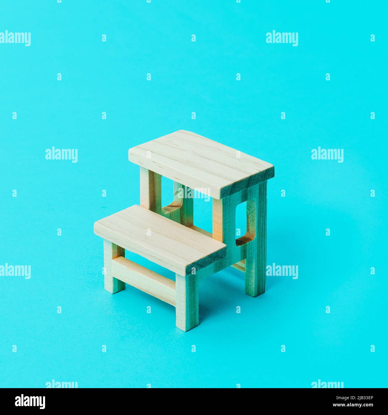 primo piano di una scrivania scuola in legno su sfondo blu con un po' di spazio vuoto intorno ad essa Foto Stock
