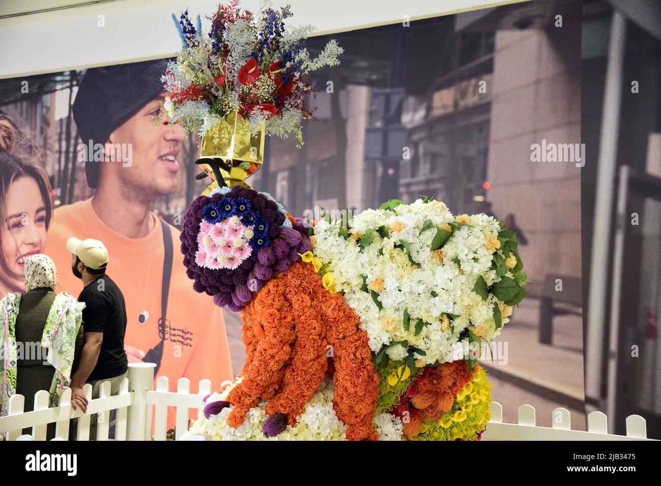Manchester, Regno Unito, 2nd giugno 2022. La gente posa accanto ad un 'Queen Bee' nel centro commerciale Arndale. Il Manchester Flower Show torna nel centro di Manchester, Regno Unito, dal 2nd al 5th giugno 2022. Situato nel centro commerciale superiore del centro commerciale Arndale, questa bella mostra è stata creata da Wild in Art con l'upcycling di una scultura di api dal precedente Wild in Art Bee Trail attraverso la città. Ricoperta di fiori artificiali, questa installazione comprende una vera corona di fiori progettata da RANA Fiori. Credit: Terry Waller/Alamy Live News Foto Stock