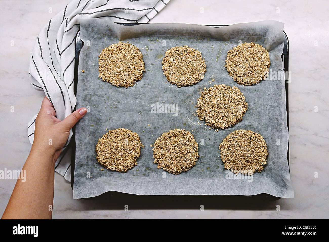 Biscotti di farina d'avena cruda su una teglia da forno pronta per la cottura. Biscotti fatti in casa, cottura e cibo sano Foto Stock