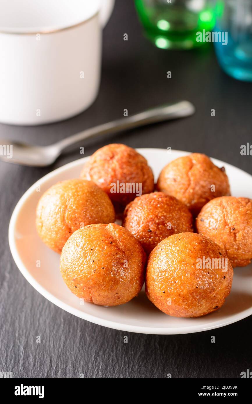 palline di semola fritte su un piatto, servito gustoso e spuntino leggero per il tè, vista da primo piano di una palle dolci prese in profondità di campo Foto Stock