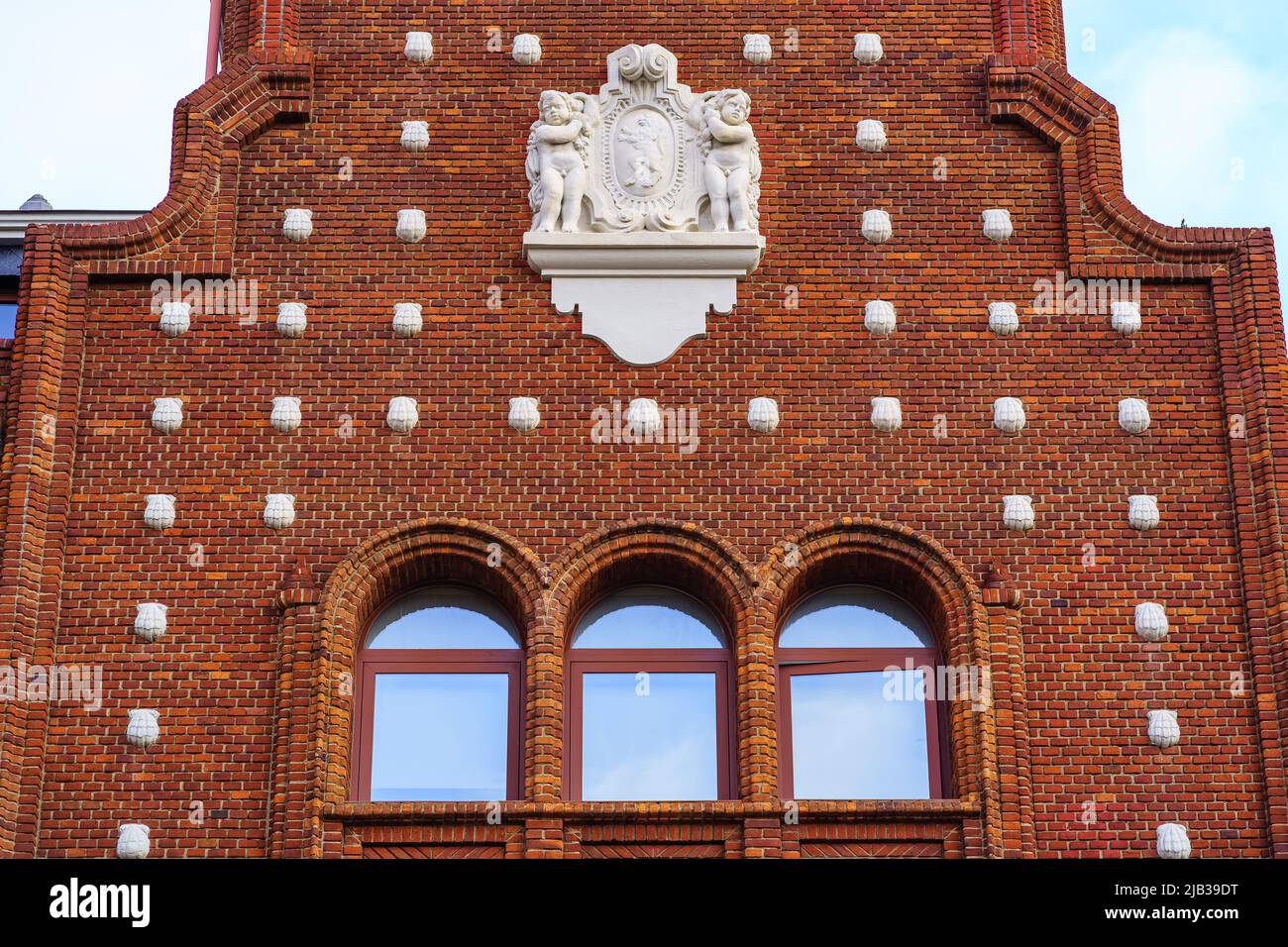 Facciata di edificio in mattoni e decorazione di conchiglie in pietra, Leon Spagna. Foto Stock