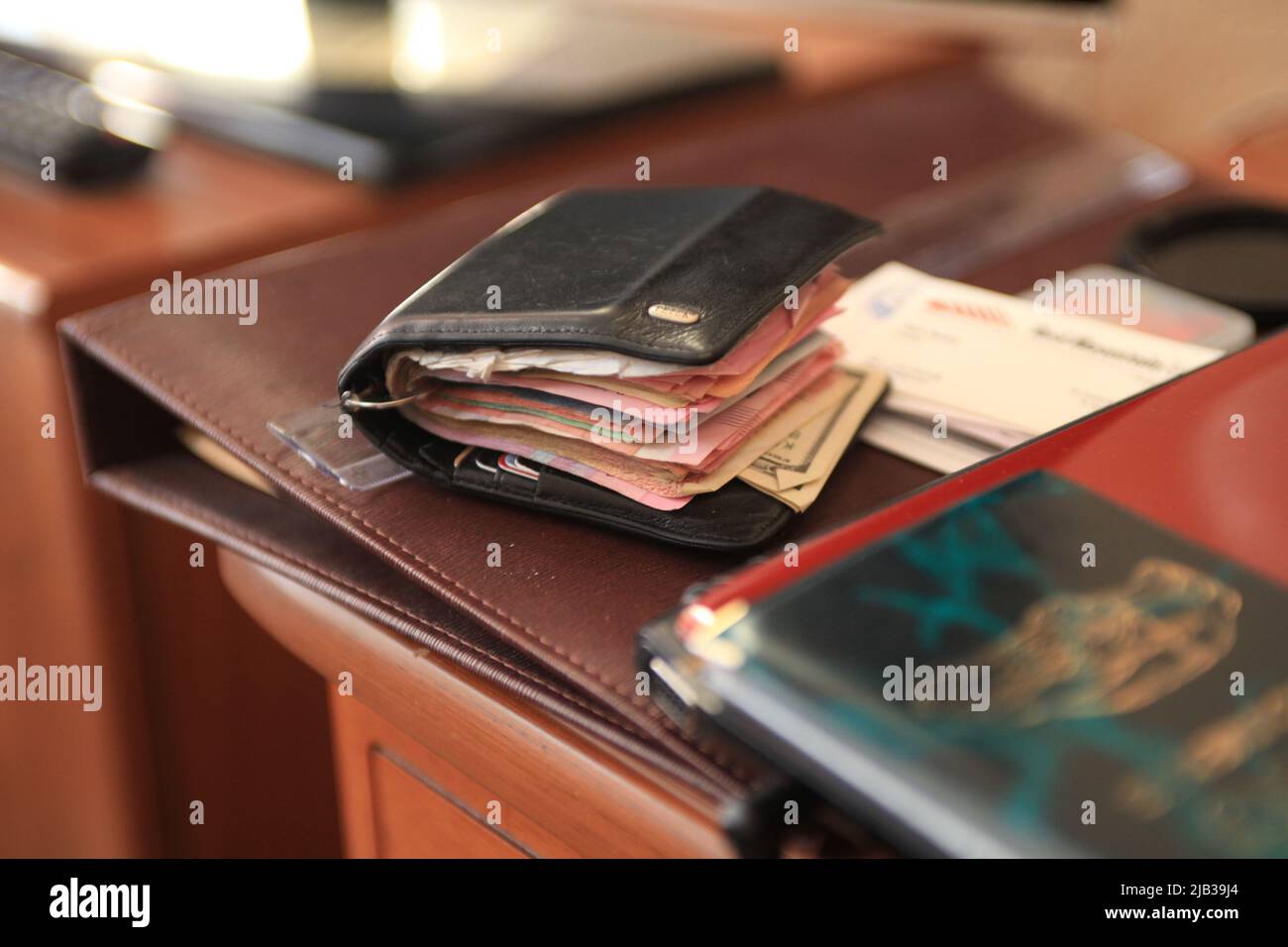 Spesso portafoglio di un ricco e sporco con dollari e altre banconote, simbolo di una vita frenetica e turbolenta prima dell'età del denaro digitale Foto Stock