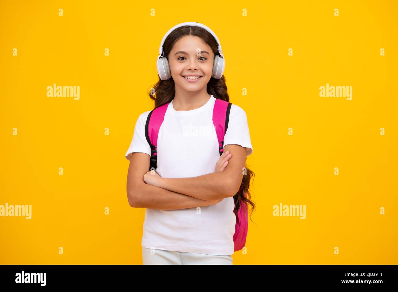 Ragazza della scuola, studente adolescente in cuffie su sfondo giallo isolato studio. Concetto di scuola di musica. Foto Stock