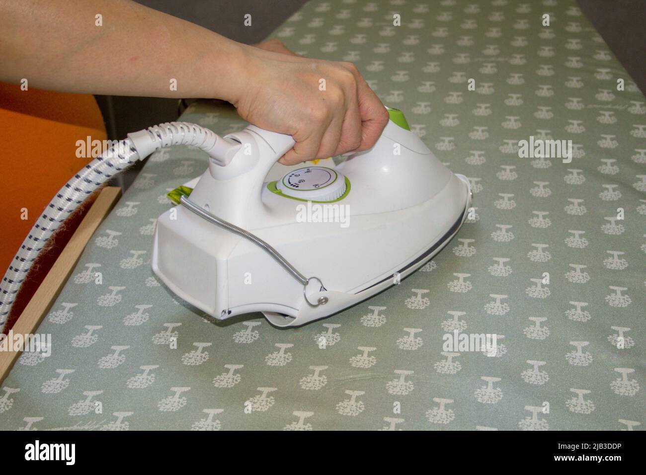 Immagine della mano di una donna che stira a casa. Foto Stock