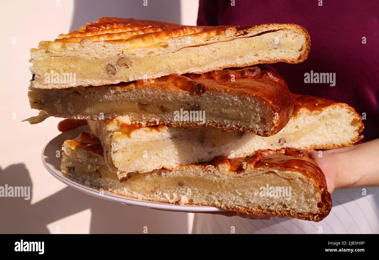 Donna che tiene un piatto di pane armeno tradizionale dolce affettato chiamato Gata Foto Stock