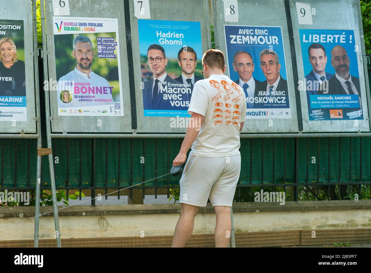 Parigi, Francia - 2 giugno 2022 : un giovane che guarda i vari ritratti dei manifesti della campagna a Parigi Foto Stock