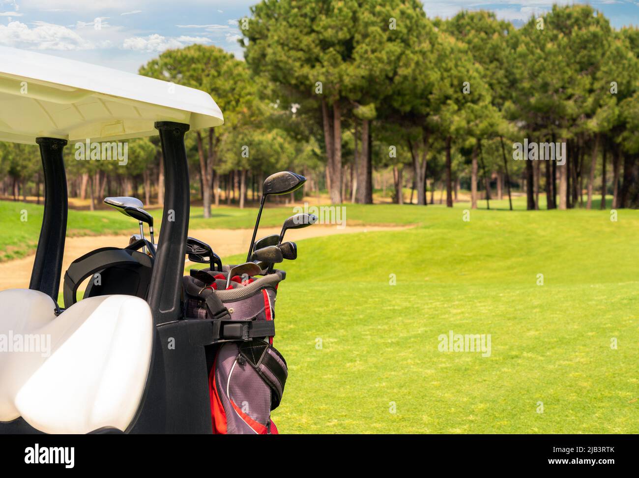 Set di attrezzature da golf in borse da golf sul retro di un golf cart su un bel campo da golf Foto Stock