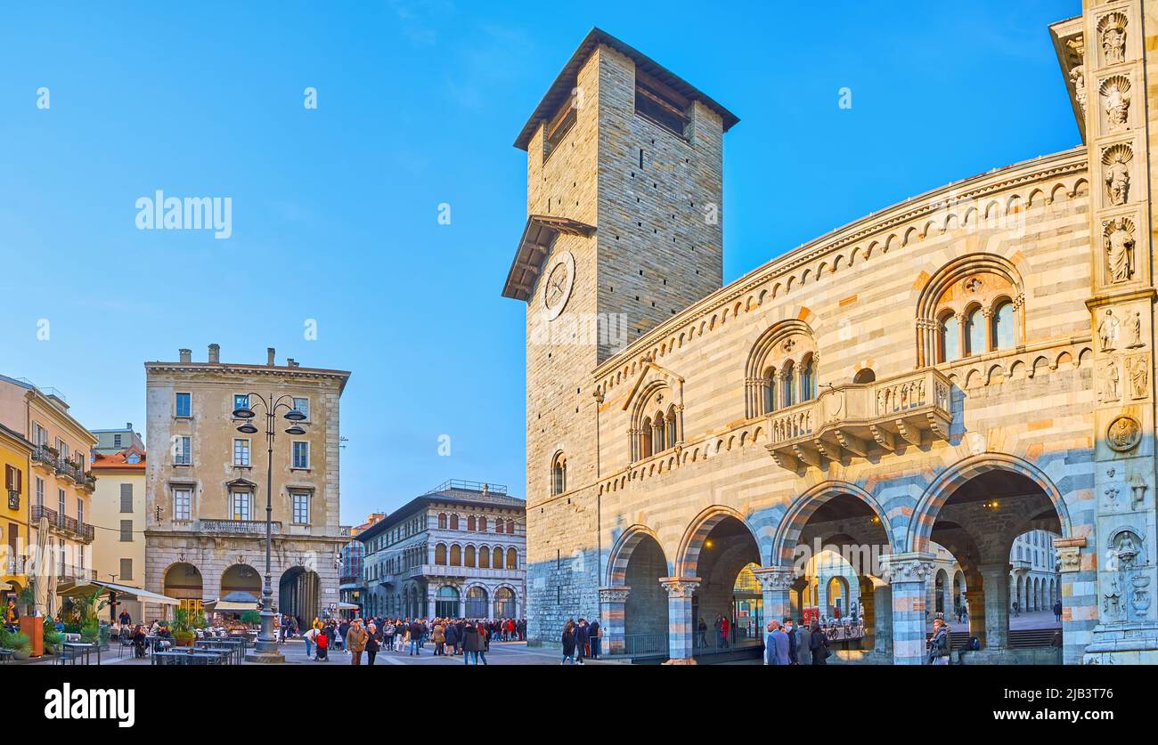 COMO, ITALIA - 20 MARZO 2022: Panorama di Piazza del Duomo con facciata di Palazzo Broletto, la sua torre di orologio, case storiche e ristoranti Foto Stock