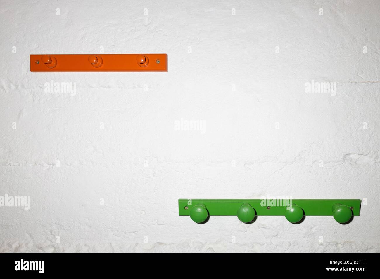 Due appendiabiti in legno multicolore su sfondo bianco. Store concept, vendita, design, appendiabiti vuoto. Spazio di copia per il testo. Foto Stock