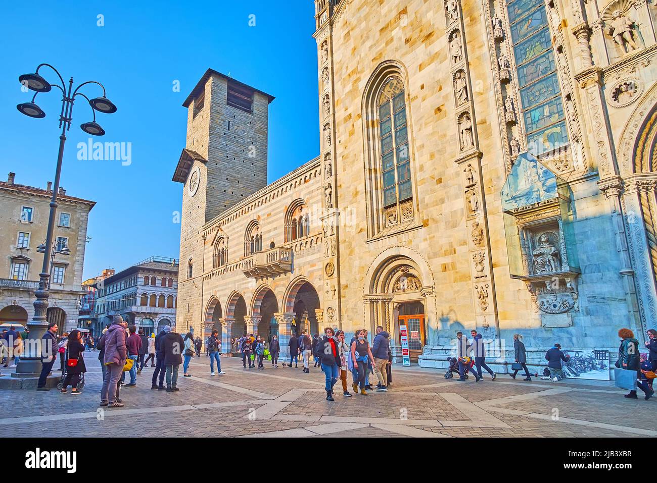 COMO, ITALIA - 20 MARZO 2022: La facciata gotica della Cattedrale di Santa Maria Assunta, la facciata e il campanile di Palazzo Broletto, situato in Piazza del Duom Foto Stock