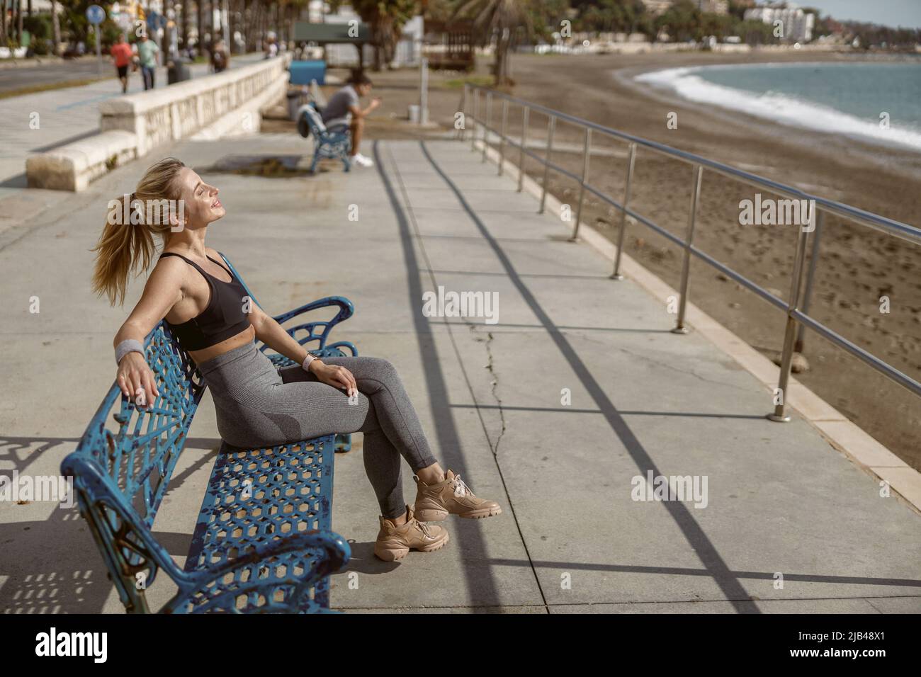 Bella giovane donna che riposa dopo l'allenamento nella natura Foto Stock