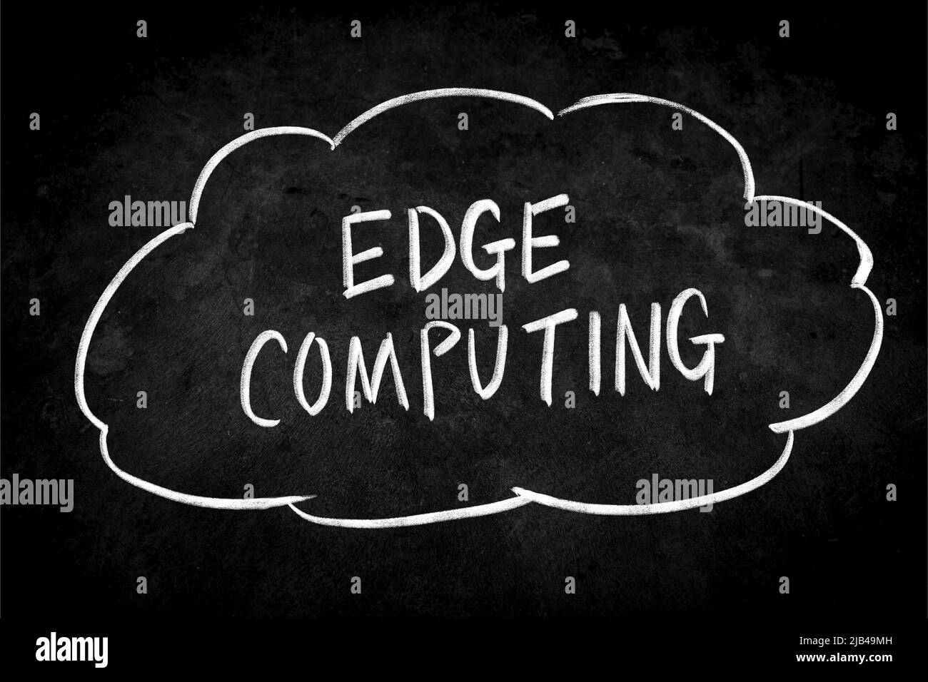 Primo piano Phrase Edge Computing scrivendo a mano gesso bianco su lavagna. La superficie della lavagna è polverosa e ruvida. Foto Stock