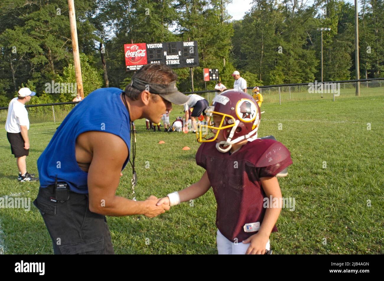 Allenatore parlare con il bambino a contatto completo pratica di calcio sul gioco e le regole di apprendimento ragazzo bambino ragazzo Foto Stock