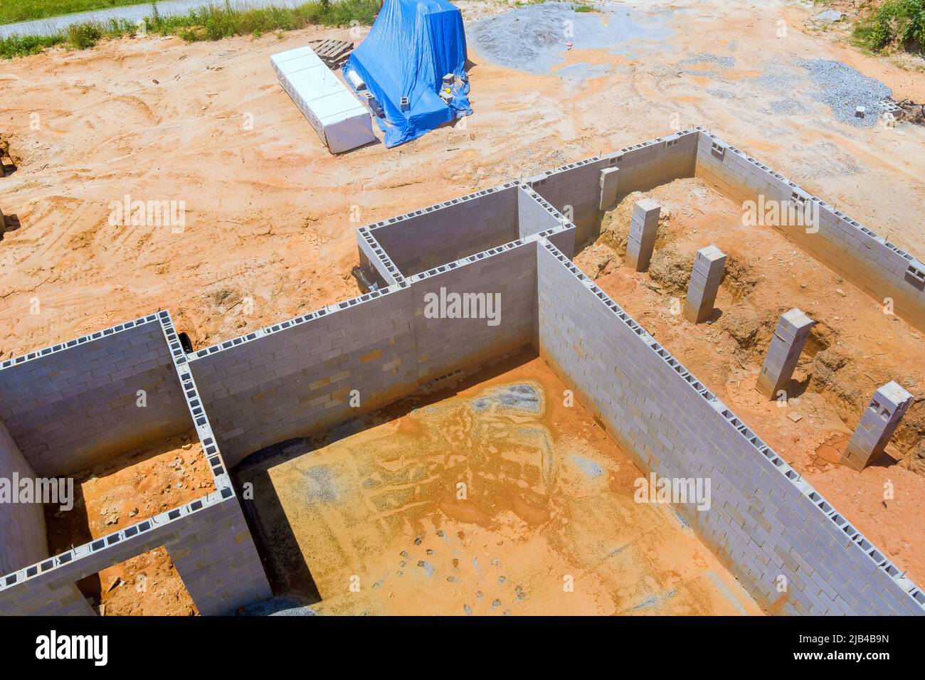 Costruzione muratore calcestruzzo blocchi fondazione per la costruzione di una nuova casa una vista dall'alto aerea Foto Stock