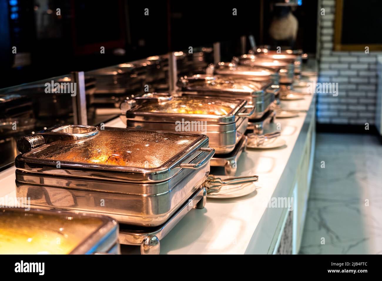 Molti piatti riscaldati a buffet sono pronti per il servizio nel ristorante dell'hotel Foto Stock