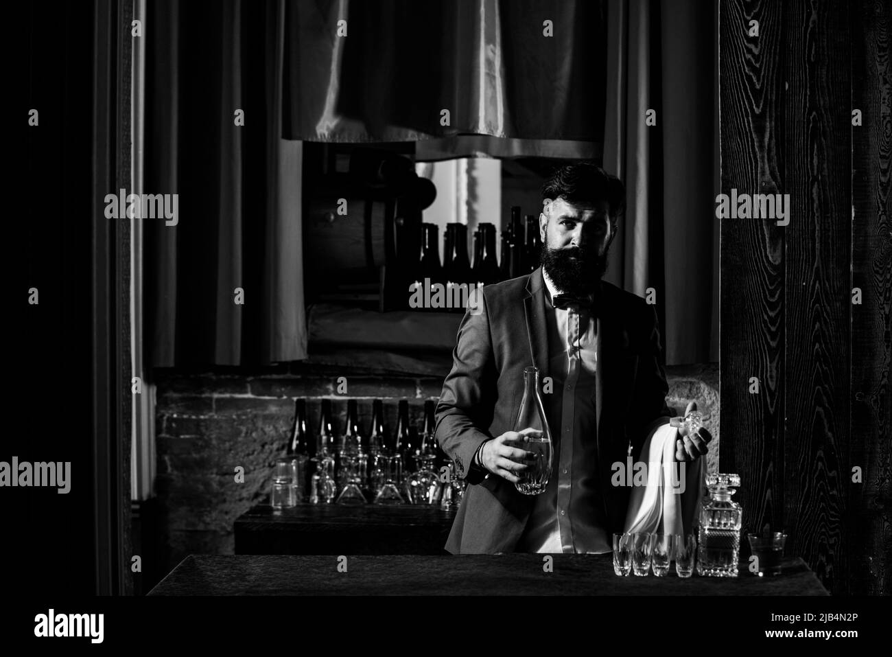 Cameriere barista. Bel barman sopportato appoggiato sul bancone bar. L'esperto bar man sta facendo un cocktail al night club. Foto Stock