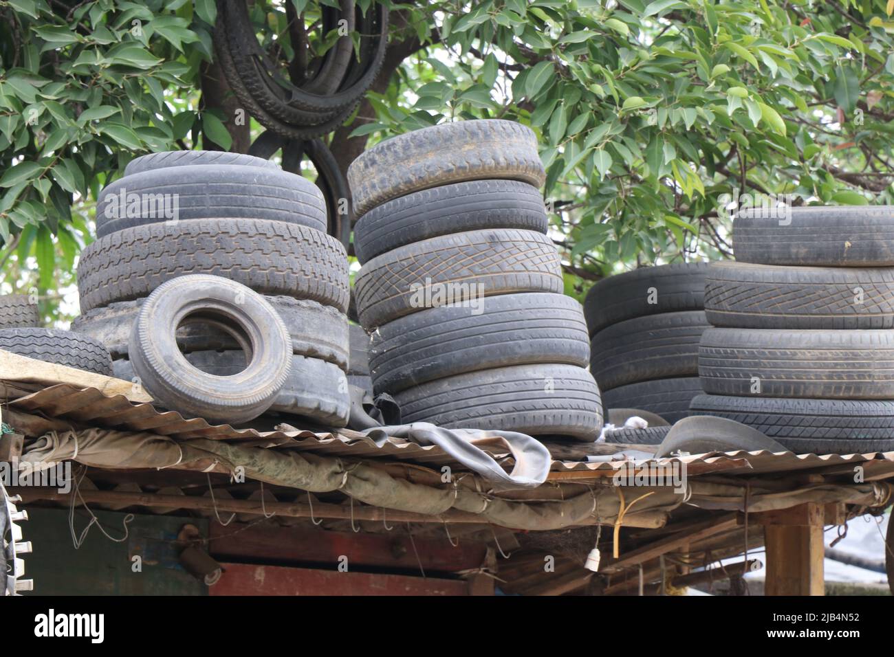 Cumulo di pneumatici per auto usati e abbandonati sulla parte superiore del tetto Foto Stock