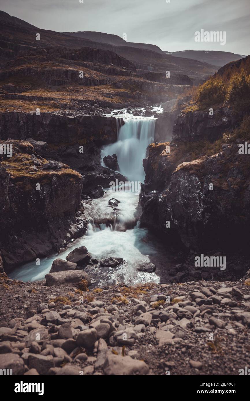 Bellissima cascata di fossardalur in islanda con un bellissimo paesaggio intorno. Tempo nuvoloso ma ancora molto bello da vedere. Foto Stock