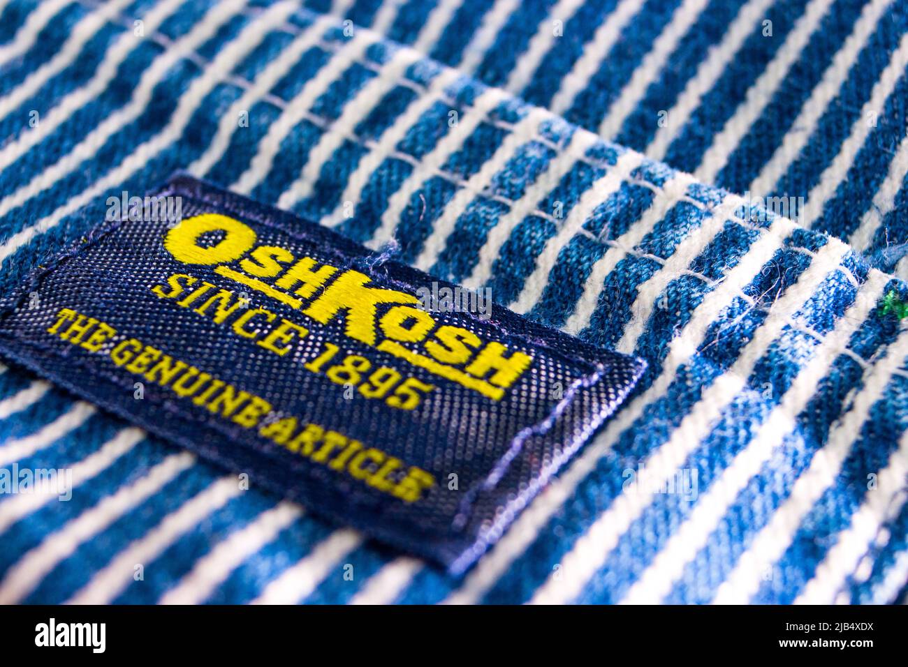 Il marchio di Oshkosh sulle sue tute a righe in hickory. Oshkosh B'gosh è un'azienda di abbigliamento statunitense fondata a Oshkosh, Wisconsin, nel 1895. Foto Stock