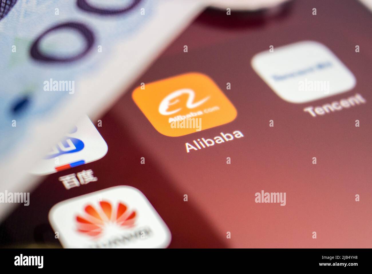 Logo Alibaba, fondato il 4 aprile 1999 a Hangzhou, Zhejiang, con loghi cinesi di grandi aziende tecnologiche (Baidu, Tencent e Huawei) e denaro su un iPhone. Foto Stock