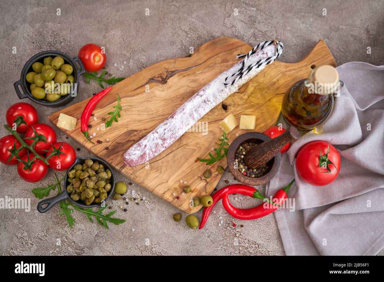 Salsiccia spagnola fuet salame e verdure su una cucina domestica Foto Stock