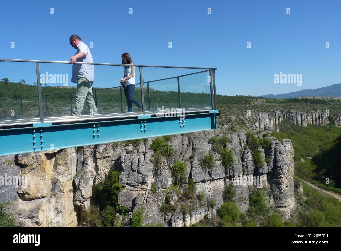 Due persone su una passerella in metallo sopraelevata che si affaccia sulla Rugged Cliff e sulla vegetazione Foto Stock