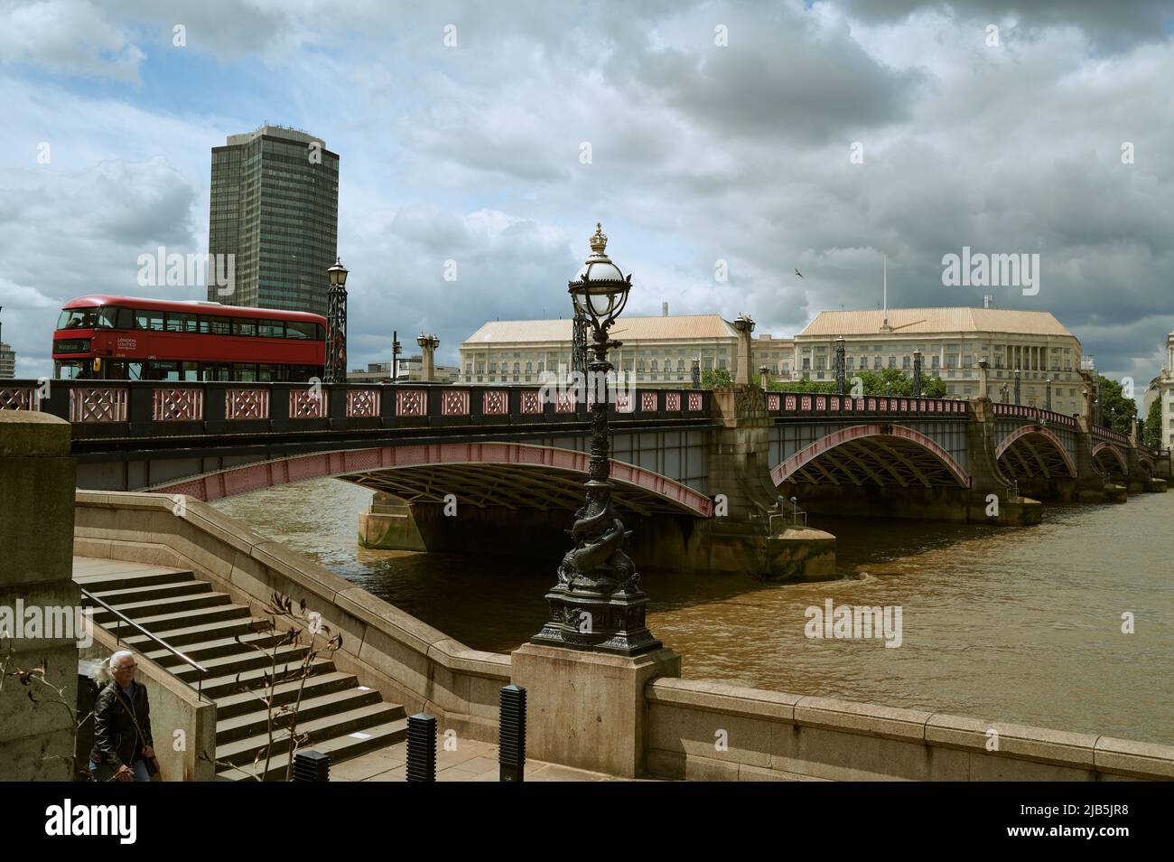 LondonUK - 29 maggio 2022: Vista sul Tamigi di colore marrone / colorato e ponte Lambeth con bus rosso e la torre millbank di passaggio in giorno di sole con Foto Stock