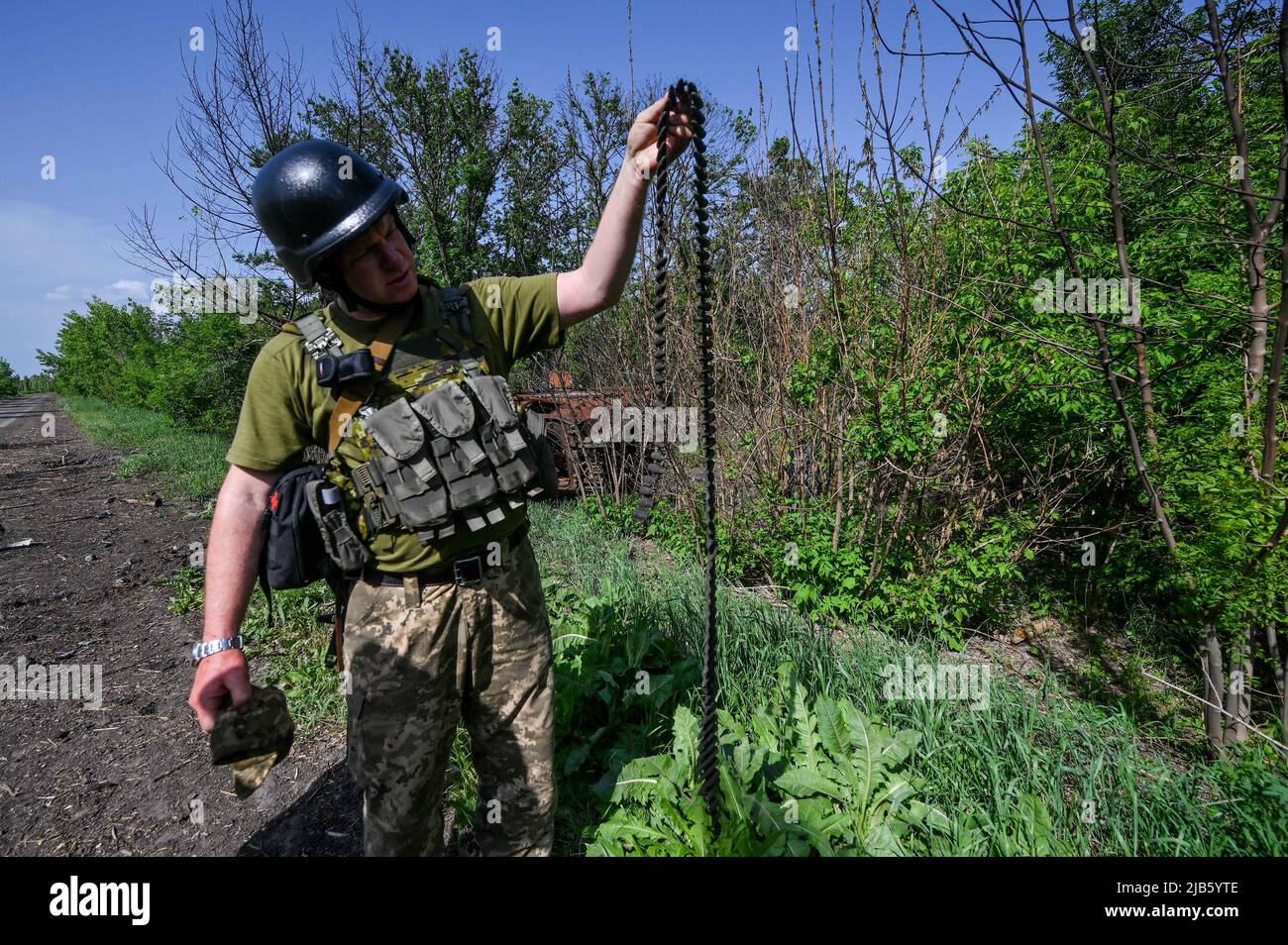 Un serviceone ucraino detiene una cintura di munizioni ricoperta di fuliggine sul lato stradale tra il polo di Zelene e i villaggi di Novopil, regione di Donetsk, Ucraina orientale, 31 maggio 2022. Foto di Dmytro Smoliyenko/Ukrinform/ABACAPRESS.COM Foto Stock