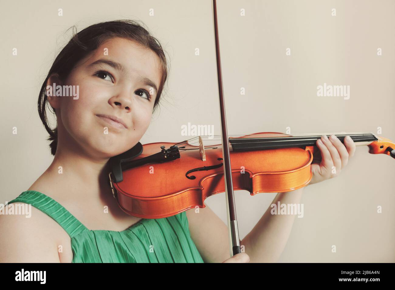 Bambina che gioca un violino, espressione facciale. Foto Stock