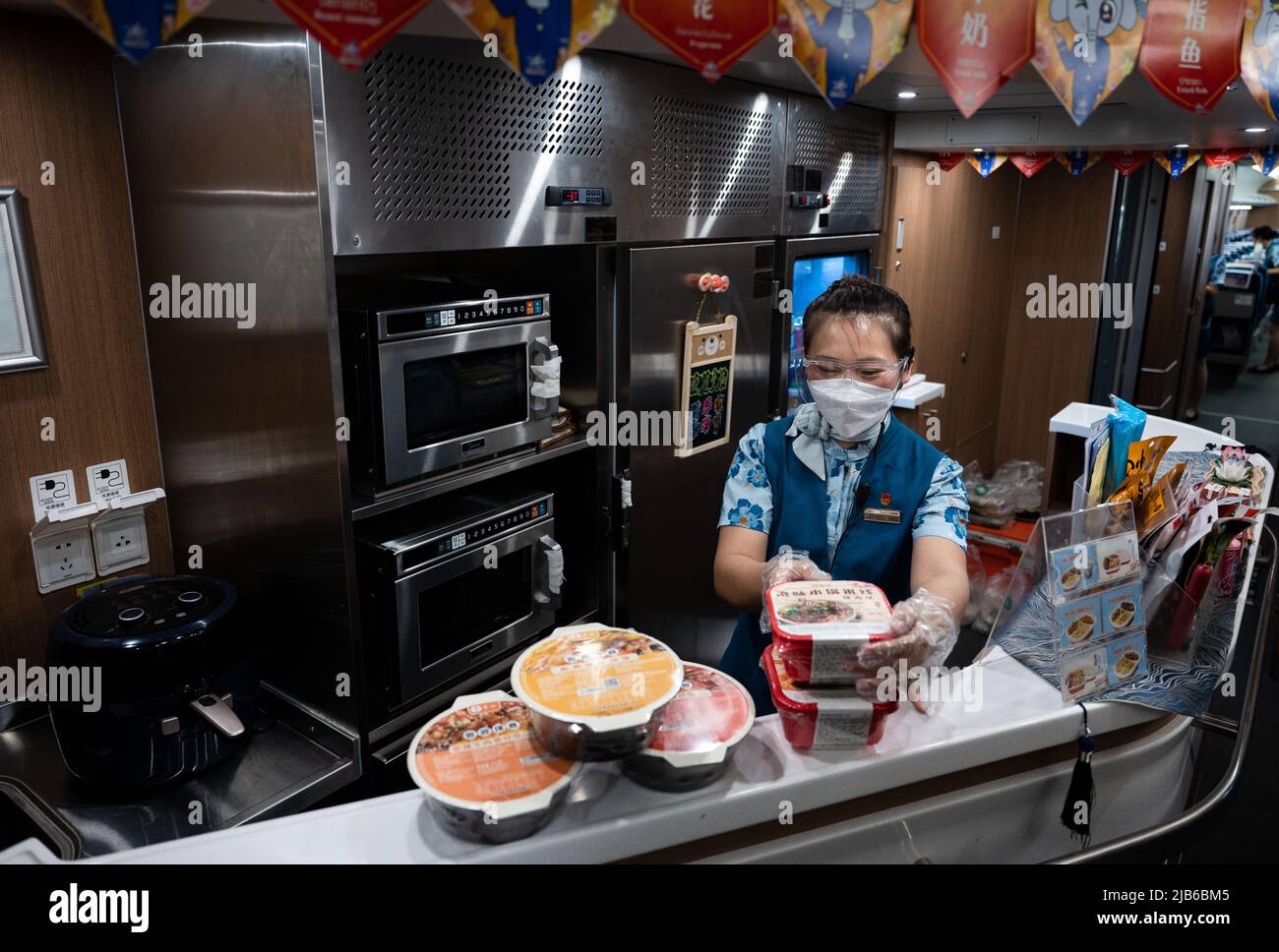 (220603) -- KUNMING, 3 giugno 2022 (Xinhua) -- una stewardess di China Railway Kunming Bureau Group Co., Ltd. Organizza il cibo su un treno ad alta velocità nella provincia di Yunnan della Cina sudoccidentale, 2 giugno 2022. La ferrovia Cina-Laos, con un semestre di attività, ha consegnato oltre 4 milioni di tonnellate di merci a partire da giovedì, ha affermato l'operatore ferroviario cinese. Come progetto di riferimento nell'ambito dell'iniziativa Belt and Road, la ferrovia di 1.035 km collega la Kunming cinese con la capitale laotiana Vientiane. (Xinhua/Wang Guansen) Foto Stock