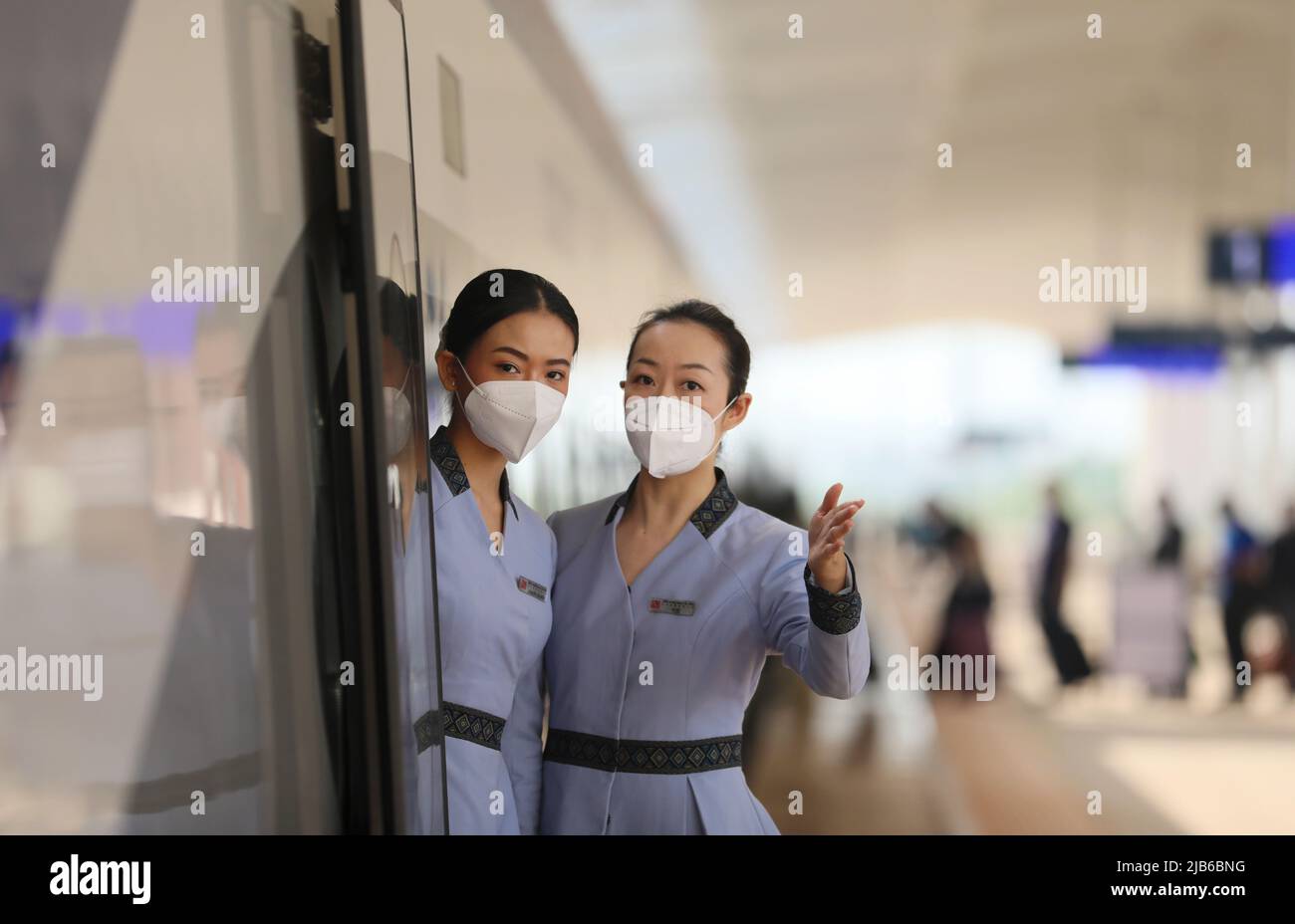 (220603) -- VIENTIANE, 3 giugno 2022 (Xinhua) -- le Stewardesses della Laos-China Railway Co., Ltd. (LCRC) aspettano i passeggeri accanto ad un treno Lane Xang EMU alla Stazione Vientiane della China-Laos Railway in Laos il 24 maggio 2022. La ferrovia Cina-Laos, con un semestre di attività, ha consegnato oltre 4 milioni di tonnellate di merci a partire da giovedì, ha affermato l'operatore ferroviario cinese. Come progetto di riferimento nell'ambito dell'iniziativa Belt and Road, la ferrovia di 1.035 km collega la Kunming cinese con la capitale laotiana Vientiane. (Foto di Yang Yongquan/Xinhua) Foto Stock