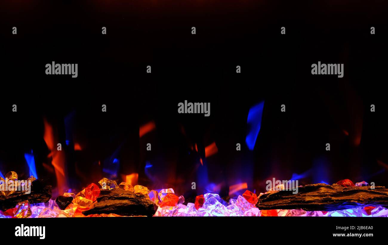 vista sul camino elettrico con fiamma artificiale scintillante, decorazioni per gli interni, fiamma blu e arancione. Foto Stock