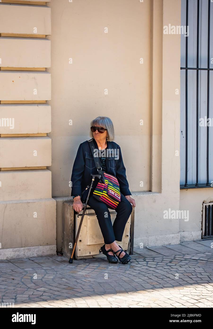 Signora anziana che prende una pausa dal camminare a Beziers, Francia. Foto Stock