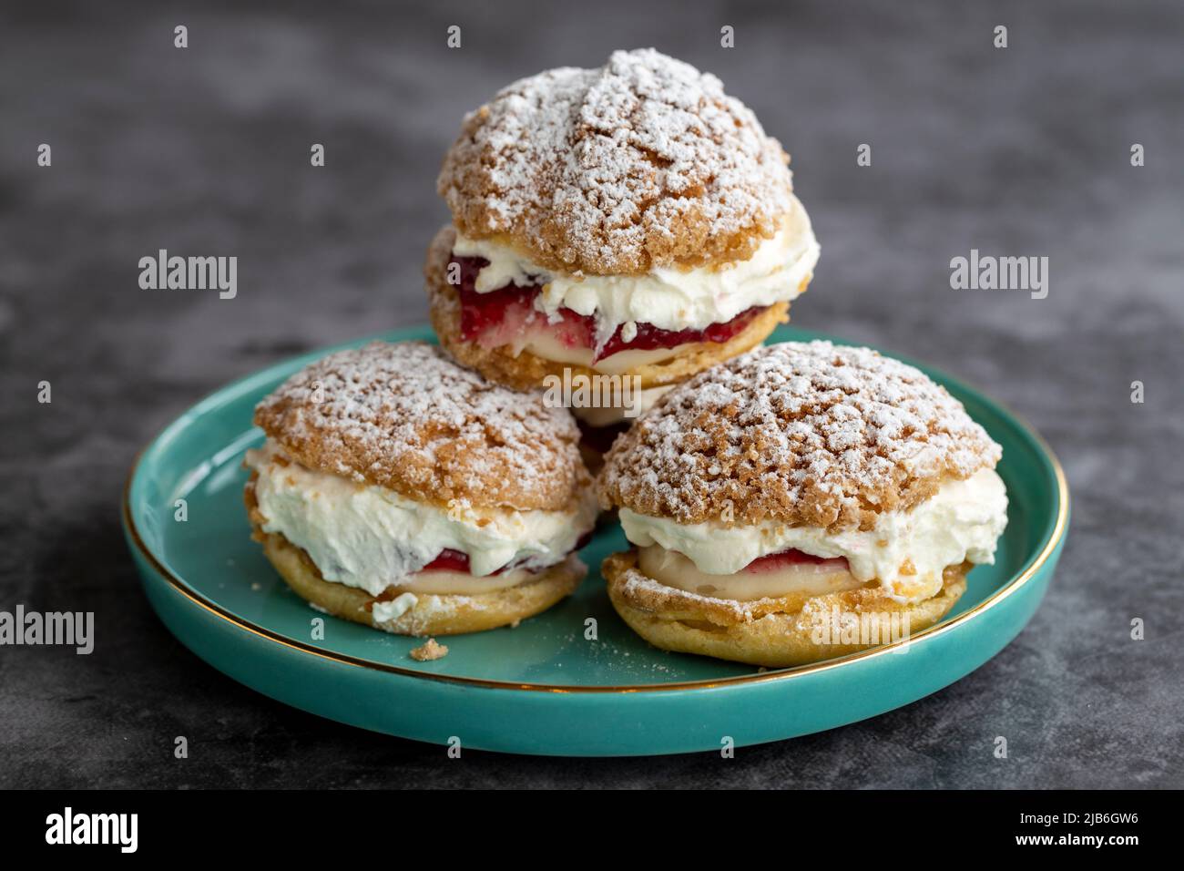 Torta con salsa di lamponi e panna. Prodotto di pasticceria. Snack dolce su sfondo scuro. Primo piano Foto Stock