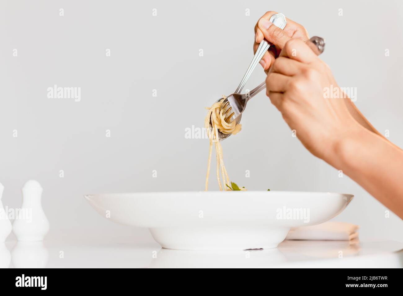 Forchetta e cucchiaio da mangiare spaghetti salsa di crema al tartufo. Foto Stock