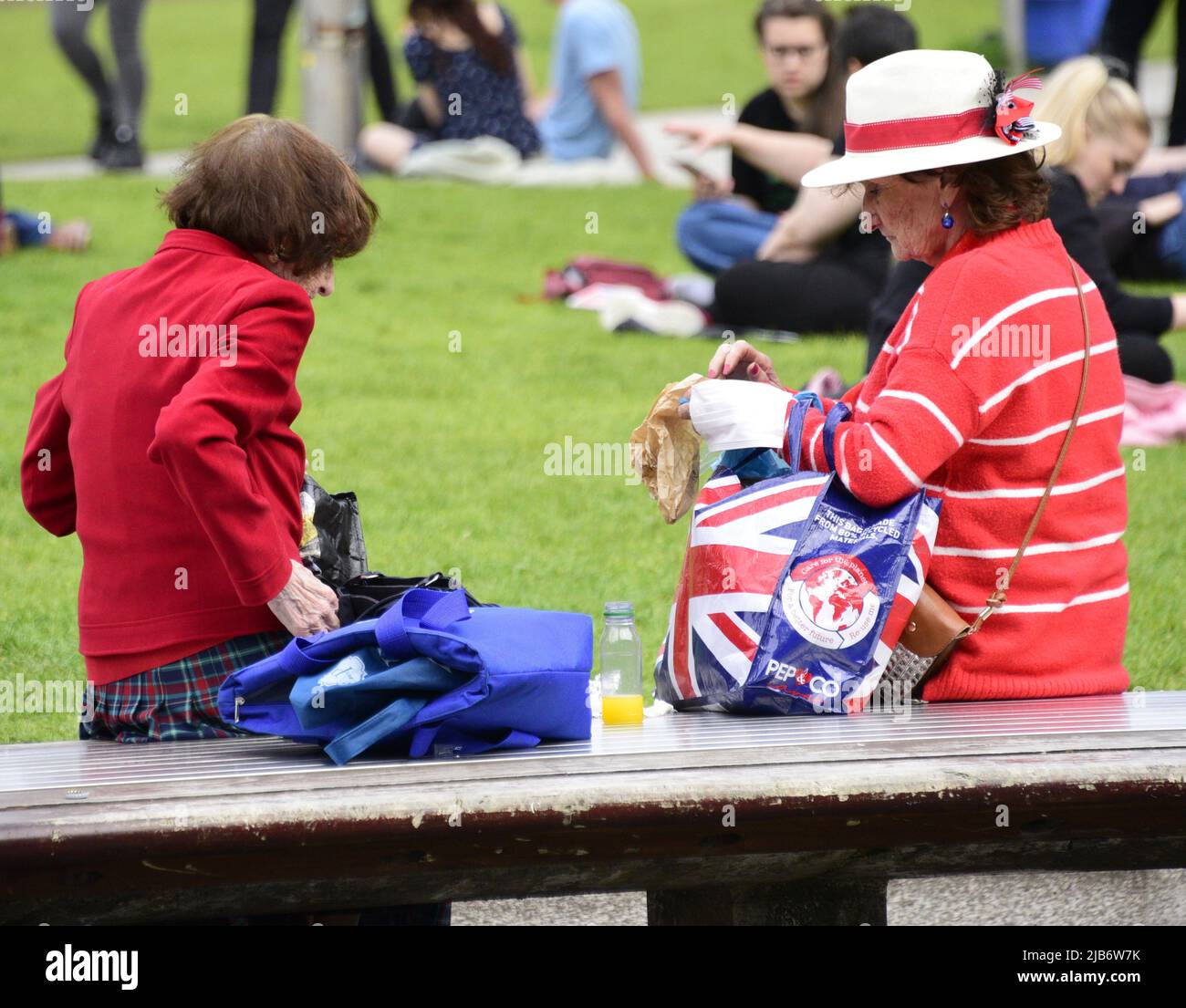Manchester, Regno Unito, 3rd giugno 2022. Due donne, una con una borsa Union Jack, riposano nei Piccadilly Gardens, nel centro di Manchester. La vita quotidiana per le strade del centro di Manchester, Inghilterra, Regno Unito, Isole britanniche durante il Giubileo extra Bank Holiday Friday. Venerdì 3rd giugno è la festa ufficiale del Platinum Jubilee, una festa in più in occasione del 70th anniversario della Regina come monarca. Credit: Terry Waller/Alamy Live News Foto Stock