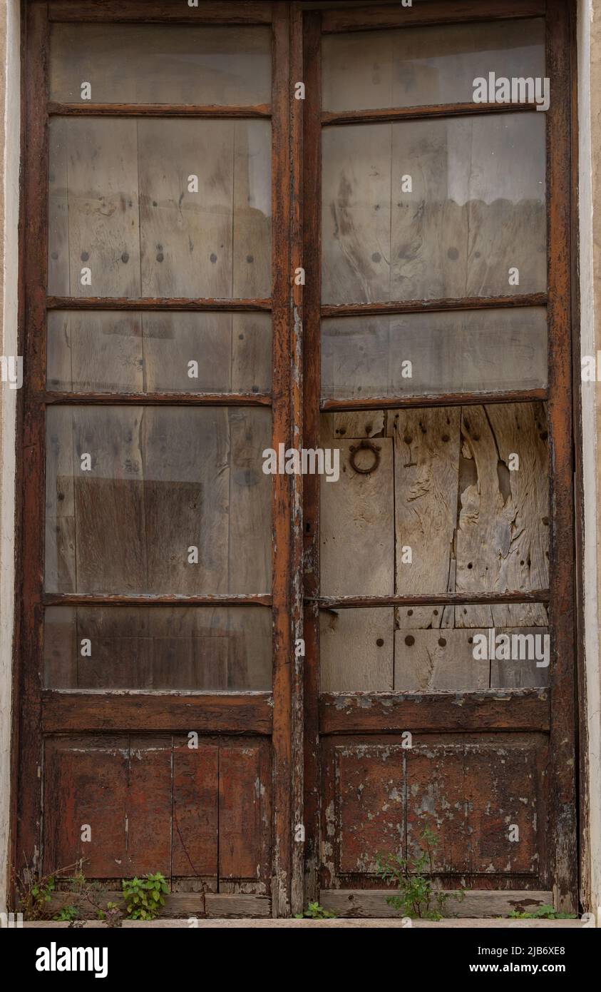 Primo piano di una porta in legno e vetro di una casa, in stato di abbandono e rovina. Case abbandonate nelle zone rurali della Spagna Foto Stock